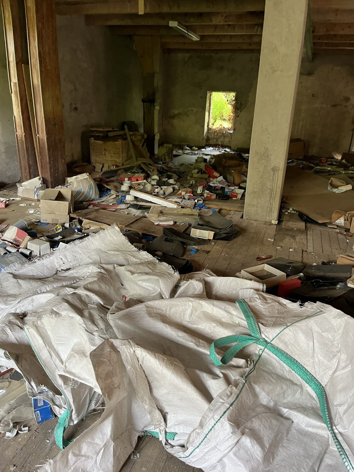 Atelier encombré de cartons, sacs et matériel avant débarras